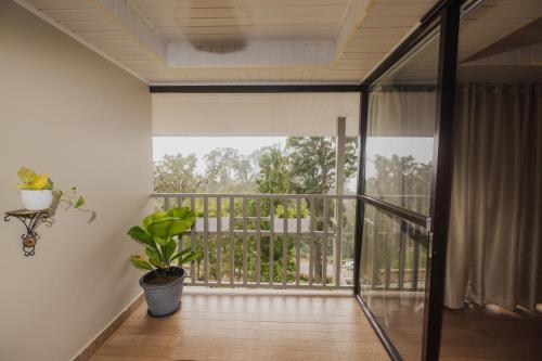 a room with a balcony with a potted plant at Misty Courtyard Resort in Chinnakanal