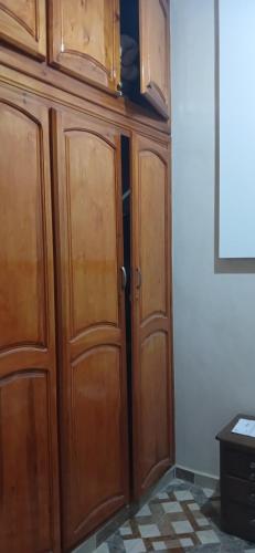 een houten kast met twee deuren in een kamer bij شقة مفروشة للكراء اليومي بمراكش in Marrakesh