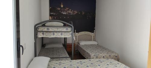 Cette petite chambre comprend 2 lits et un miroir. dans l'établissement APART-DUPLEX-ATICO Tomares, à Tomares