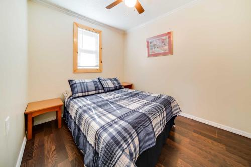 ein kleines Schlafzimmer mit einem Bett und einem Tisch in der Unterkunft Geneva Cottage with Patio - Walk to Park, Lake Erie! in Geneva-on-the-Lake