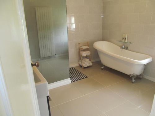 a white bathroom with a tub and a shower at junction house in Stockton-on-Tees