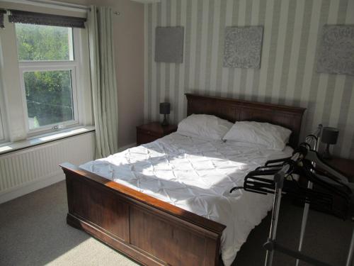 a bedroom with a bed with white sheets and a window at junction house in Stockton-on-Tees