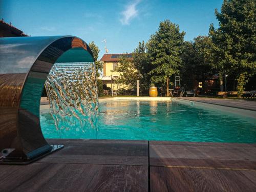 a fountain in front of a swimming pool at La Tenuta di Santo Stefano Agri Resort & Spa in Fossano