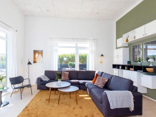 ein Wohnzimmer mit einem blauen Sofa und einem Tisch in der Unterkunft Captivating Holiday home in L kken with Whirlpool in Løkken