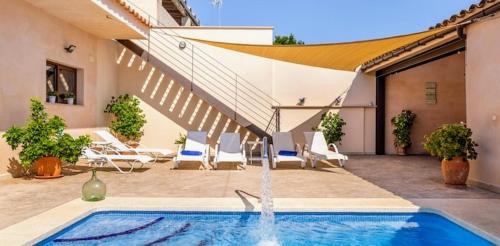 a swimming pool with a fountain in a courtyard at Casa Padrins de ses tanques in Ariany