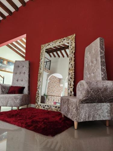 a mirror in a room with two chairs and a rug at Luxury Mansion Sant Serrant Cerca Aeropuerto Medellín Guatapé in Marinilla