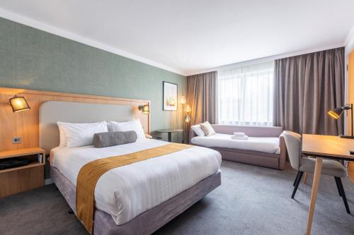 a hotel room with two beds and a desk at Holiday Inn Oxford by IHG in Oxford