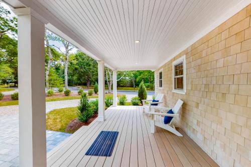 a porch with a bench and a table at The Cape House in Cotuit