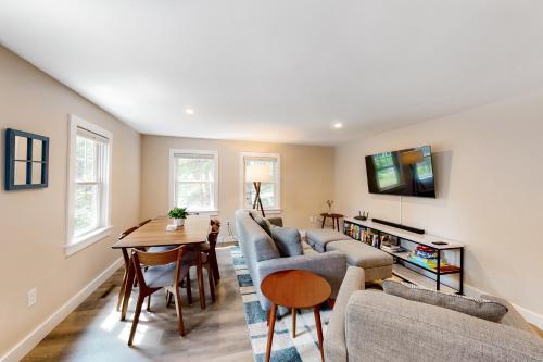 a living room with a couch and a table at The Cape House in Cotuit