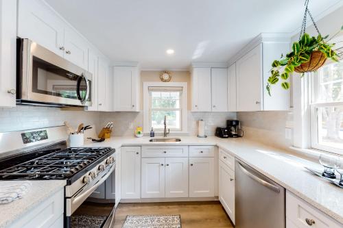 a kitchen with white cabinets and a stove at The Cape House in Cotuit
