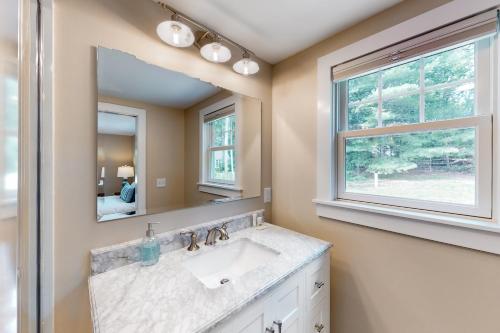 a bathroom with a sink and a mirror at The Cape House in Cotuit