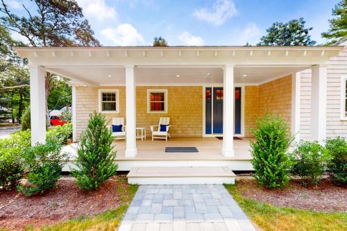 a white house with a porch and a patio at The Cape House in Cotuit