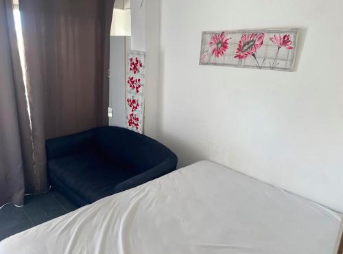 Cette chambre comprend un lit et un canapé bleu. dans l'établissement Cap d'Agde Naturist Exclusive Studio, au Cap d'Agde