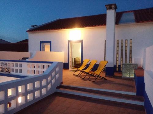 a house with two chairs on a deck at night at Alentejo Cante & Vinho in Ferreira do Alentejo