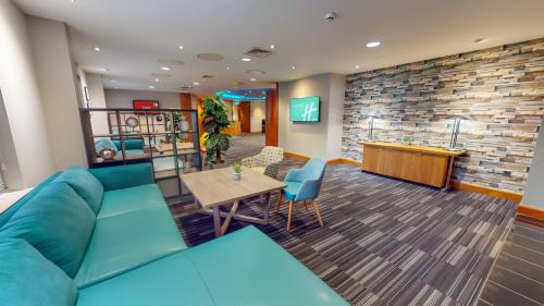 a living room with a couch and a table at Holiday Inn Oxford by IHG in Oxford