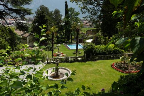 a garden with a fountain and a swimming pool at Villa Angelica in Riva del Garda