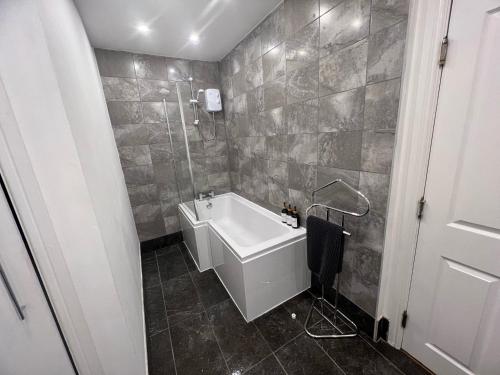 y baño con bañera y lavamanos. en Spacious ground floor suite comfortably sleeps up to eight en Halifax