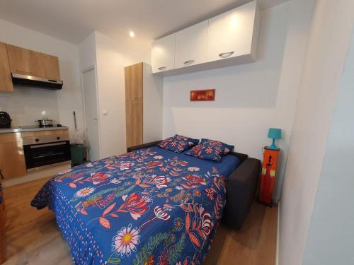 een slaapkamer met een bed met een blauw dekbed bij Appartement Vigne in Nancy