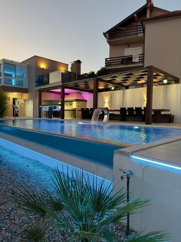 a swimming pool in front of a house at Holiday Home Korda in Čapljina