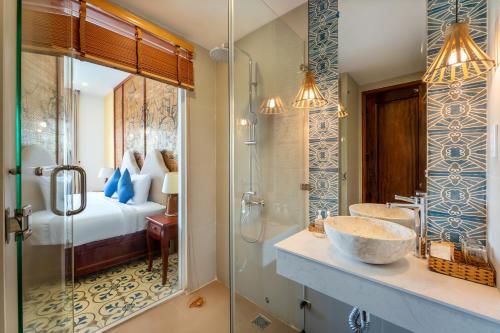 a bathroom with a sink and a shower and a bed at ZEN RETREAT HOI AN in Hoi An