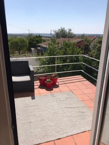 a balcony with a couch and two potted plants at Casa do Mercador by Portus Alacer in Avis
