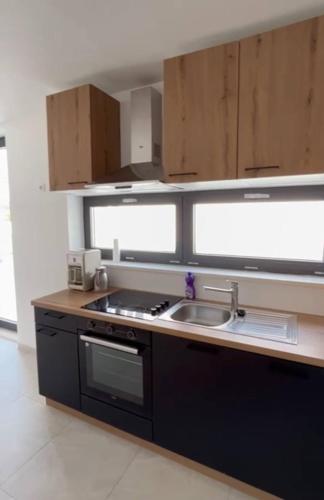 a kitchen with a sink and a stove top oven at Villa royale with shared pool in Hvar