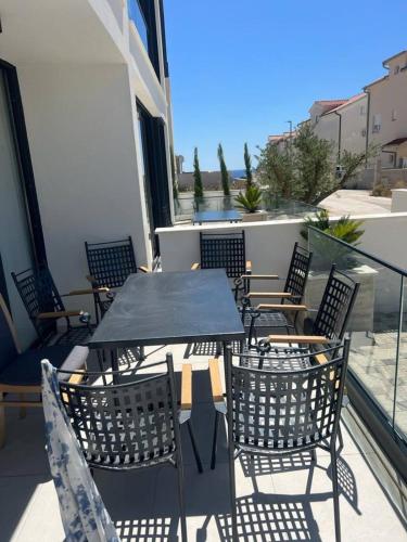 a patio with tables and chairs on a balcony at Villa royale with shared pool in Hvar