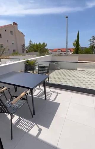 a table and chairs on the roof of a building at Villa royale with shared pool in Hvar