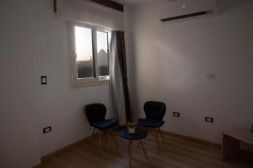 a room with three chairs and a table and a window at Palm Pyramids View INN in Cairo