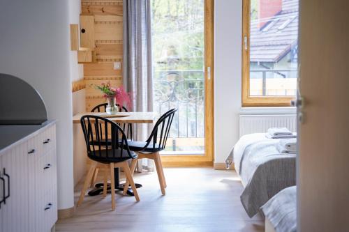 a room with a table and chairs and a window at Bella Monte in Szczyrk