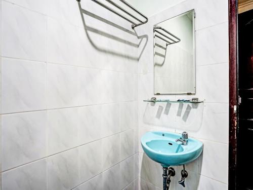 a bathroom with a blue sink and a mirror at SUPER OYO 91805 Hotel Wisma Bari in Palembang