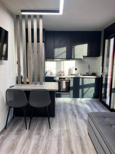 a kitchen with black cabinets and a table and chairs at Grand Kourouta in Kourouta