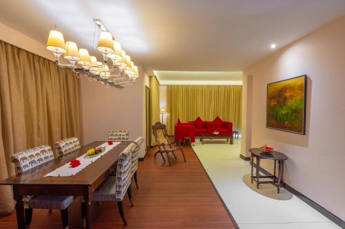 a dining room and living room with a table and chairs at O Hotel Goa, Candolim Beach in Candolim