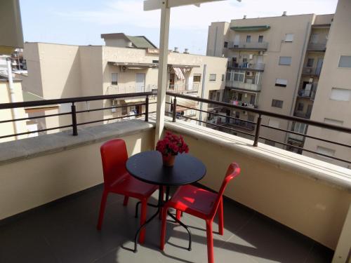 a table and two chairs on a balcony at Attico Stazione - Montello 16 in Bari