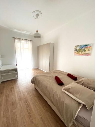 - une chambre avec un lit doté d'oreillers rouges dans l'établissement Large Haussmanian appartment in the heart of Nice, à Nice