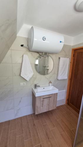 a bathroom with a sink and a mirror at Bungaja Chalets in Shkodër