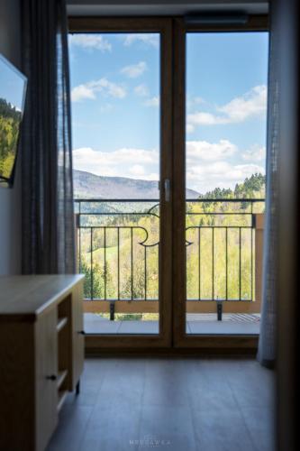 a room with a window with a view of a balcony at Bella Monte in Szczyrk