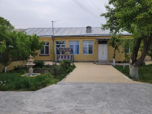 a yellow house with a driveway in front of it at Artush & Raisa B&B in Gyumri