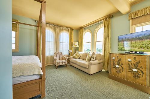 a bedroom with a bed and a couch and a tv at Ashland Springs Hotel in Ashland