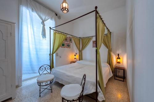 a bedroom with a canopy bed and two chairs at Tenuta Belvedere in Otranto