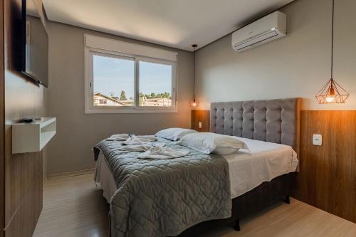 1 dormitorio con 1 cama y TV en Dom Pedro 304 - Stay House Temporada, en Canela