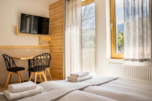 a bedroom with a bed with a desk and a window at Bella Monte in Szczyrk