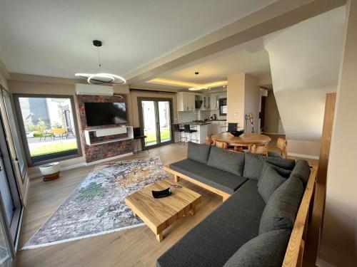 uma sala de estar com um sofá e uma mesa em Villa Evasion A em Seferihisar