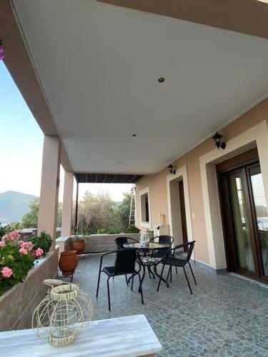 a patio with a table and chairs on a building at villa kastanos in Amaliápoli