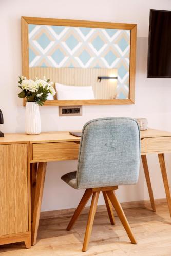 a desk with a chair and a mirror at DAYS City Suites Athens in Athens