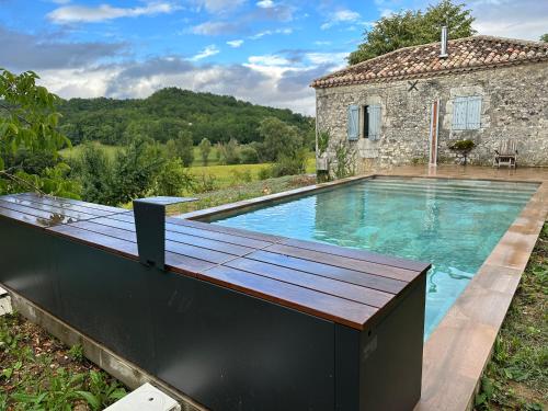 - une piscine avec une terrasse en bois à côté d'une maison dans l'établissement Maison charmante nature piscine chauffée, à Montlauzun