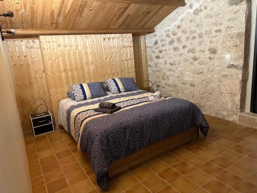 um quarto com uma cama com travesseiros azuis em um quarto em Maison charmante nature piscine chauffée em Montlauzun