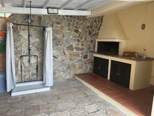 a kitchen with a stone wall and a stove at Villetta Indipendente Sardegna in Villaputzu