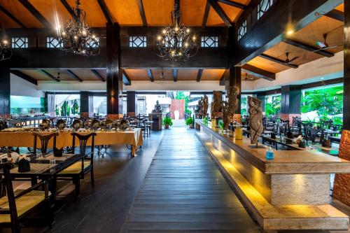 a restaurant with tables and chairs and a bar at O Hotel Goa, Candolim Beach in Candolim