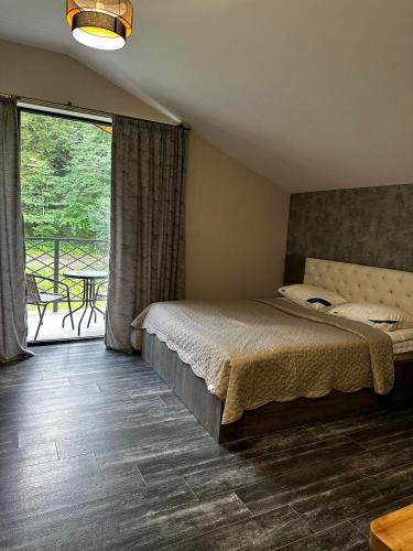 Un dormitorio con una cama y un balcón con una mesa. en Apart Hotel Falkon, en Bakuriani